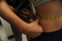 A service member’s waist is measured during a physical fitness test.