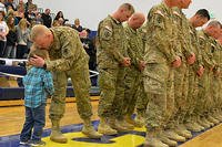 soldier greeting small child while in formation