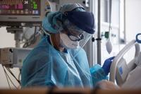 An Air Force critical care nurse checks a COVID-19 patient at Los Angeles County-USC Medical Center.