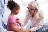 Female doctor examining little girl