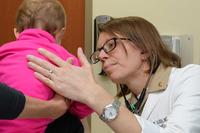 A doctor at Naval Hospital Camp Pendleton examines a young patient.