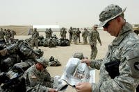 A soldier reads the Stars and Stripes newspaper in Kuwait in 2006.