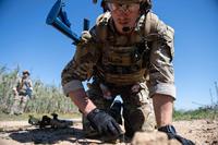 A Navy EOD tech conducts close-range reconnaissance of a buried unexploded ordnance during training