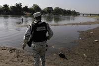 Mexican National Guard soldier stands on the bank of the Suchiate River.