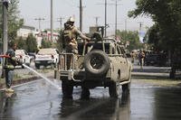 Afghan security personnel leave the scene of a roadside bomb explosion in Kabul, Afghanistan