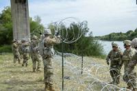 Soldiers install concertina wire along the Mexico border.