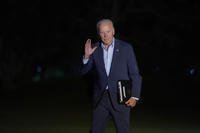 President Joe Biden waves as he walks from Marine One across the South Lawn of the White House