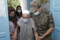 A soldier helps an elderly man to enter the vaccination center in Kesra July 13, 2021.