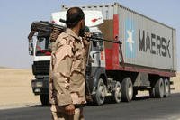 Private security contractor watches a NATO supply truck in Afghanistan