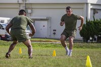 Marine performs agility drills during a high intensity tactical training (HITT) workout.