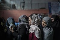 People wait at a money distribution organized by the World Food Program in Kabul