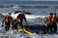 BUD/S students drag their boat back to shore.