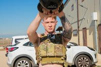 An airman performs kettlebell swings.