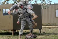 A sergeant executes a fireman's carry on a simulated casualty during the Best Warrior competition.