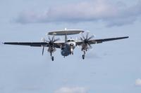 An E-2C Hawkeye approaches the USS John C. Stennis.