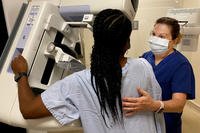 mammography technologist at Naval Hospital Jacksonville assists a patient during a mammogram