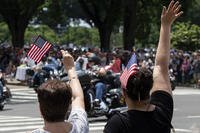 Women wave as motorcyclists participate in the 32nd Rolling Thunder demonstration.