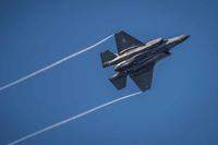 An F-35 Lightning II streaks across the sky.