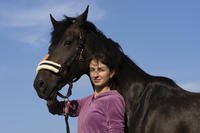 Viktoria Skliar poses for a photo with a horse.