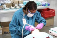 A dental hygienist from the 810th Medical Company in Charleston, S.C., provides dental care for a patient.