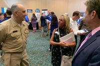 Capt. Phil Mlynarski, Naval Surface Warfare Center Dahlgren Division (NSWCDD) commanding officer, speaks with a candidate at the NSWCDD Job Fair.