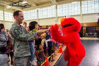 Sesame Street character Elmo gives a high-five to a member of the audience at the completion of the Sesame Street USO Experience for Military Families show at Travis Air Force Base, Calif. (Louis Briscese/U.S. Air Force) Sesame Street character Elmo at Travis Air Force Base
