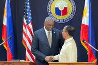 U.S. Defense Secretary Lloyd Austin shakes hands with his Philippine counterpart, Carlito Galvez Jr.
