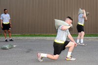 Soldiers from Headquarters Support Company, Eighth U.S. Army, conduct physical training using sandbags for extra weight while performing forward lunges in South Korea.