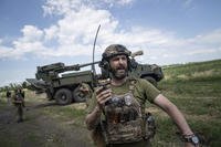 A Ukrainian service member speaks into a radio. 