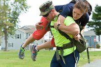 First Lt. Samuel Clark fireman-carries Staff Sgt. Aisuluu Alford during the GORUCK Light team cohesion challenge on Dover Air Force Base, Del.