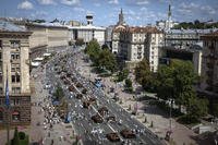 People look at a large column of burnt out and captured Russian tanks on display in Kyiv, Ukraine.