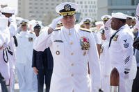Rear Adm. Fred W. Kacher salutes sideboys during a change of command ceremony