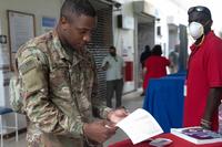 Army chaplain reads an absentee ballot while in the Post Exchange