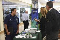 Petty Officer 1st Class Eric Muro, a Coast Guardsman assigned to Helicopter Interdiction Tactical Squadron Jacksonville, speaks with potential employers at the City of Jacksonville's Week of Valor Veterans and Military Job and Resources Fair.