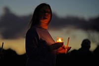 A mourner attends a candlelight vigil for the victims of this week's mass shootings