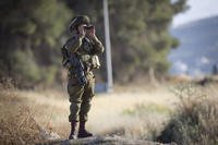 Israeli soldier uses binoculars near the West Bank city of Nablus