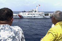 Philippine special envoy to China Teodoro Locsin Jr., right, looks at a Chinese Coast Guard ship