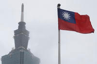 A Taiwan national flag flutters near the Taipei 101 building