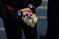 A Navy Seabee holds his medals and ribbons during a company-level uniform inspection.