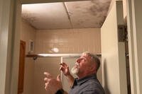 The Fort Stewart Directorate of Public Works' lead mold remediation specialist shows where a barrack room's bathroom ceiling in building 212 has mold after the room was flooded by an equipment failure.