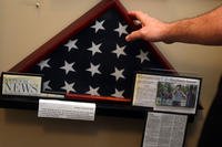 J.R. Wilson touches the display case of an American flag at The Antioch Historical Museum