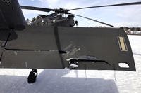 damaged Black Hawk helicopter rests on the snow