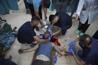 Palestinian medics treat a wounded man