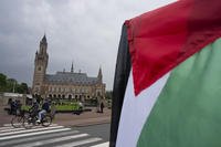 demonstrator waves the Palestinian flag outside the Peace Palace