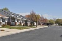 A row of houses stretch down a suburban-looking blacktopped street.