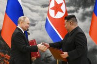 Russian President Vladimir Putin, left, and North Korea's leader Kim Jong Un exchange documents