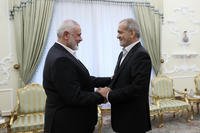 President Masoud Pezeshkian, right, shakes hands with Hamas chief Ismail Haniyeh