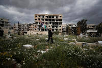 A man carries Palestinian flag in a Palestinian refugee camp of Yarmouk in Damascus, Syria