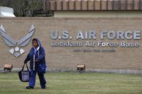 A pedestrian passes the main gate at Lackland Air Force Base in San Antonio.