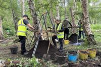 Active-duty US military personnel sieving woodland soil for human remains